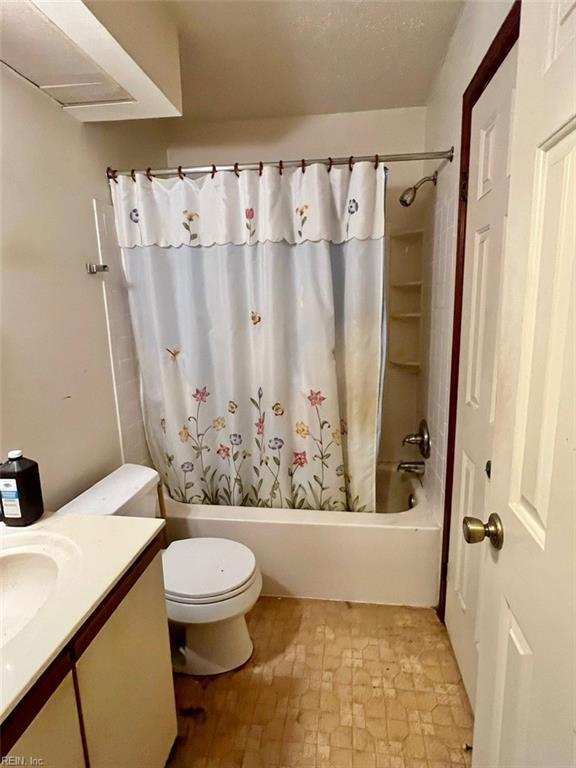 full bathroom featuring shower / tub combo with curtain, vanity, and toilet