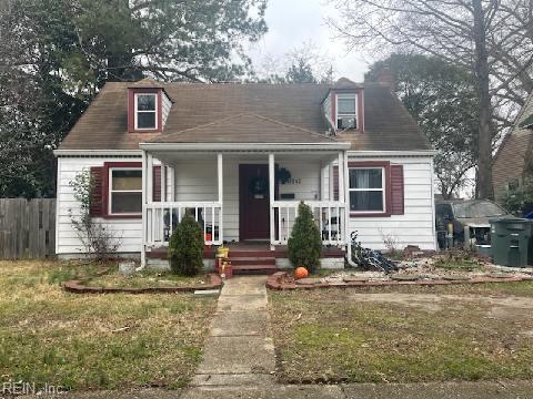 view of front of property with covered porch, a front lawn, and fence