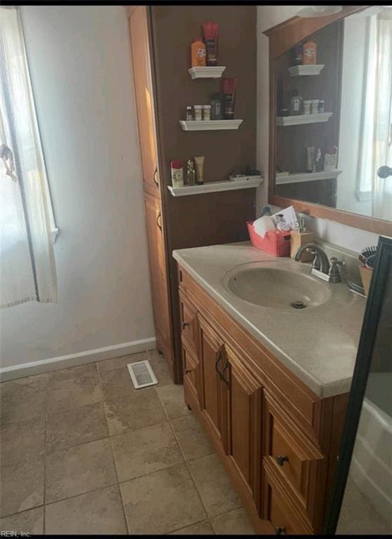 bathroom with visible vents, tile patterned flooring, vanity, and baseboards