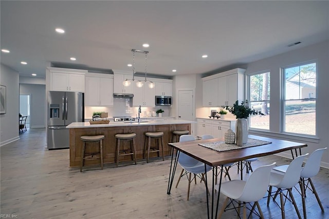 dining room with sink and light hardwood / wood-style flooring