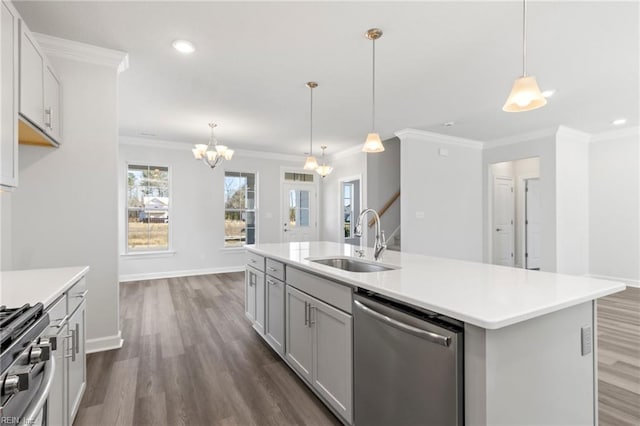 kitchen featuring sink, hanging light fixtures, appliances with stainless steel finishes, dark hardwood / wood-style flooring, and a kitchen island with sink