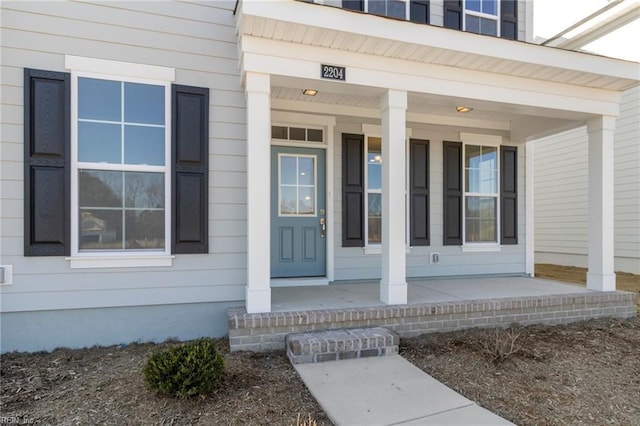 view of exterior entry featuring covered porch