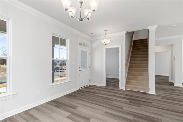 foyer with dark hardwood / wood-style flooring, crown molding, plenty of natural light, and an inviting chandelier