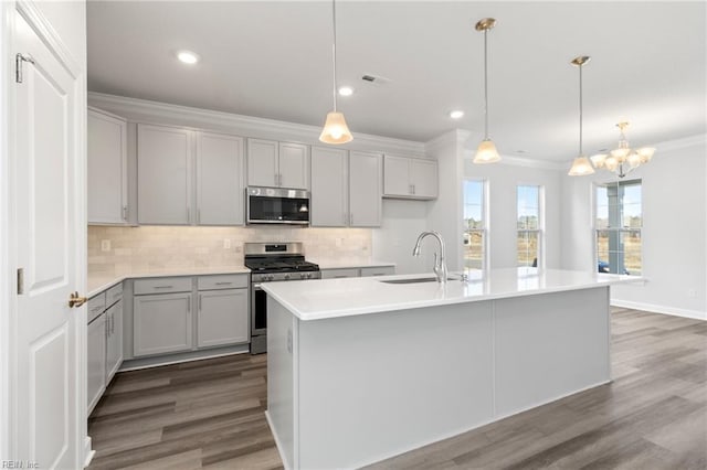 kitchen with an island with sink, appliances with stainless steel finishes, and sink