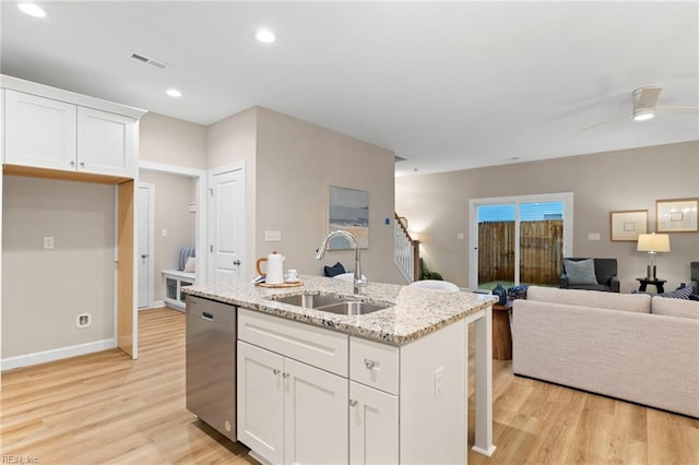 kitchen featuring white cabinetry, stainless steel dishwasher, light stone countertops, and sink