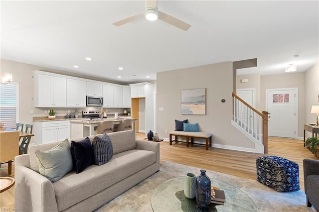 living room with ceiling fan and light hardwood / wood-style floors