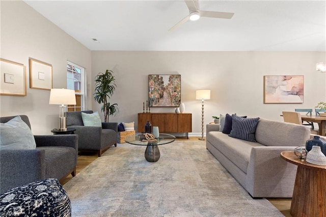 living room featuring ceiling fan with notable chandelier and wood-type flooring