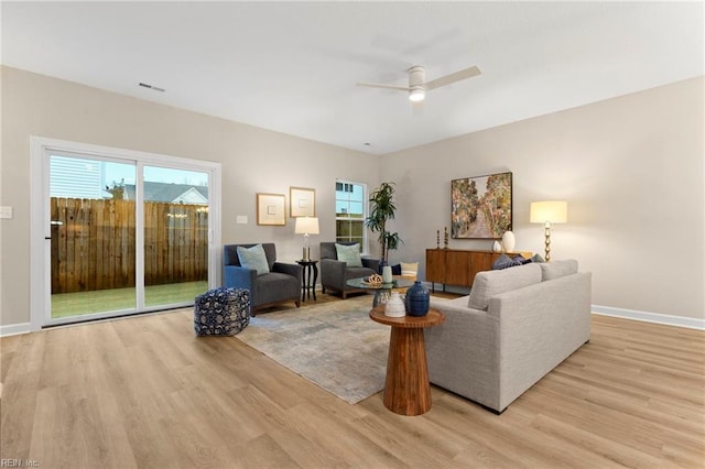 living room featuring a healthy amount of sunlight, ceiling fan, and light hardwood / wood-style flooring