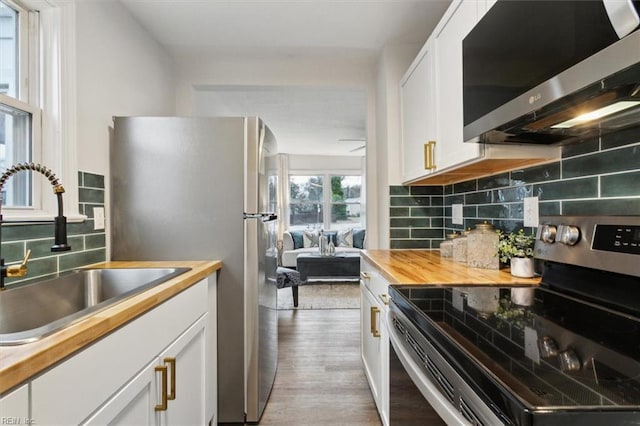 428 Hampton Roads Ave, Hampton, VA 23661 - kitchen featuring butcher block counters, sink, light hardwood / wood-style flooring, stainless steel appliances, and white cabinets