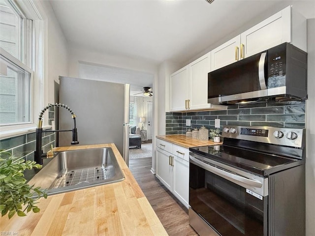 428 Hampton Roads Ave, Hampton, VA 23661 - kitchen featuring sink, butcher block countertops, tasteful backsplash, stainless steel appliances, and white cabinets