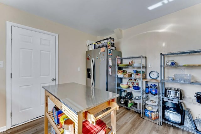 kitchen featuring wood-type flooring and stainless steel fridge with ice dispenser