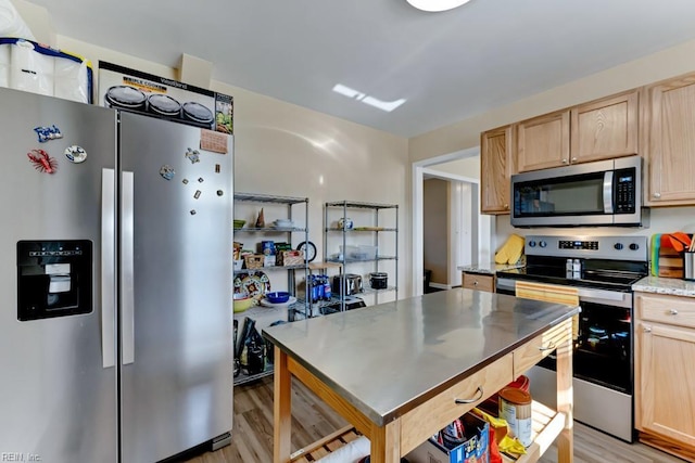 kitchen with appliances with stainless steel finishes, light wood-type flooring, and light brown cabinetry