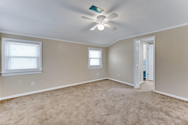 carpeted empty room with ceiling fan, lofted ceiling, and ornamental molding