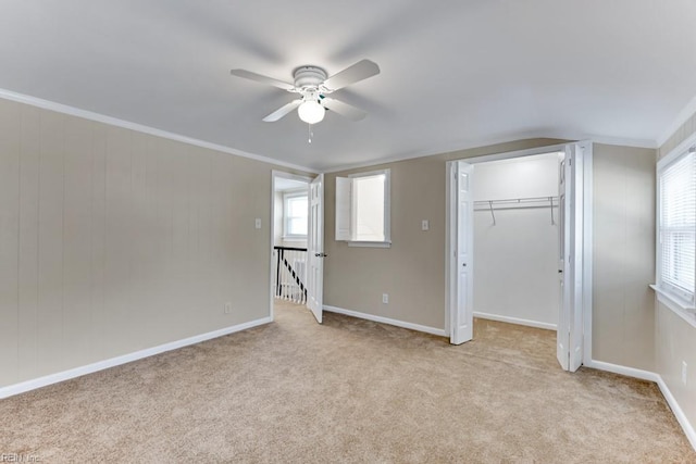 unfurnished bedroom featuring multiple windows, light colored carpet, and ornamental molding