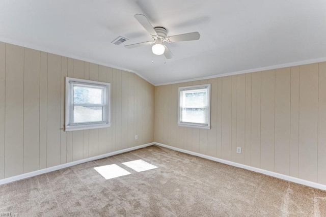 spare room featuring light carpet, plenty of natural light, lofted ceiling, and ceiling fan