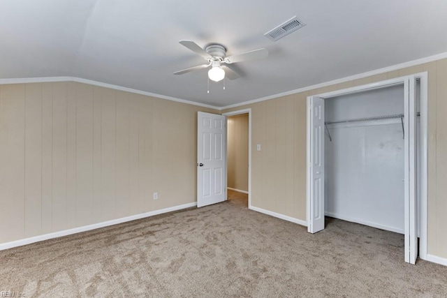 unfurnished bedroom with ceiling fan, a closet, ornamental molding, and light carpet