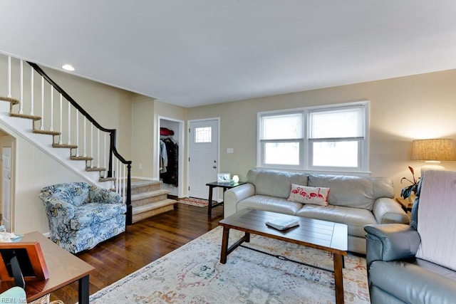 living room with dark hardwood / wood-style floors and a healthy amount of sunlight