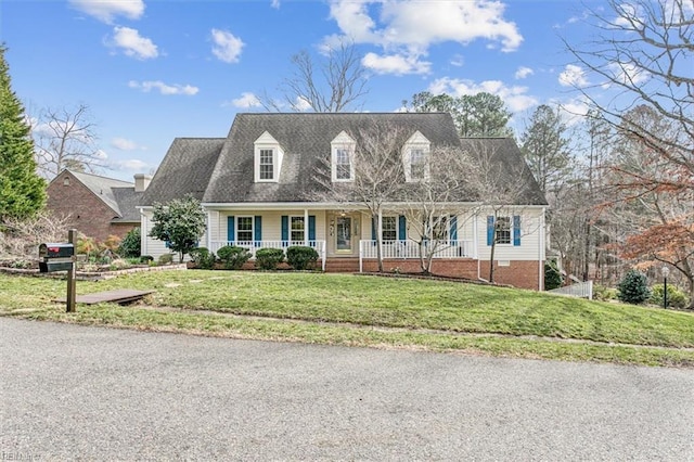 cape cod-style house featuring a front yard and covered porch