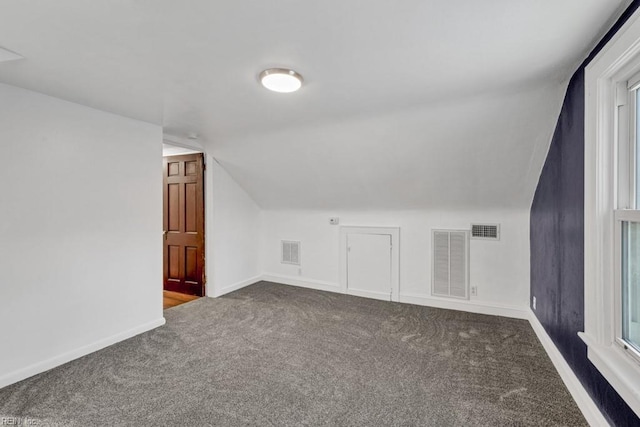 additional living space with carpet floors and vaulted ceiling