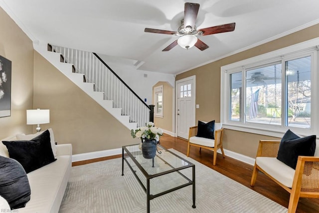 living room with wood-type flooring, ceiling fan, and crown molding