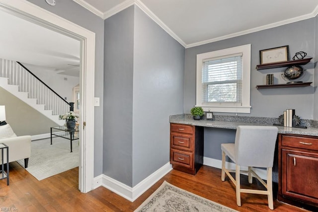 home office with ornamental molding, built in desk, and hardwood / wood-style floors