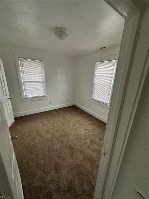 carpeted spare room with a healthy amount of sunlight