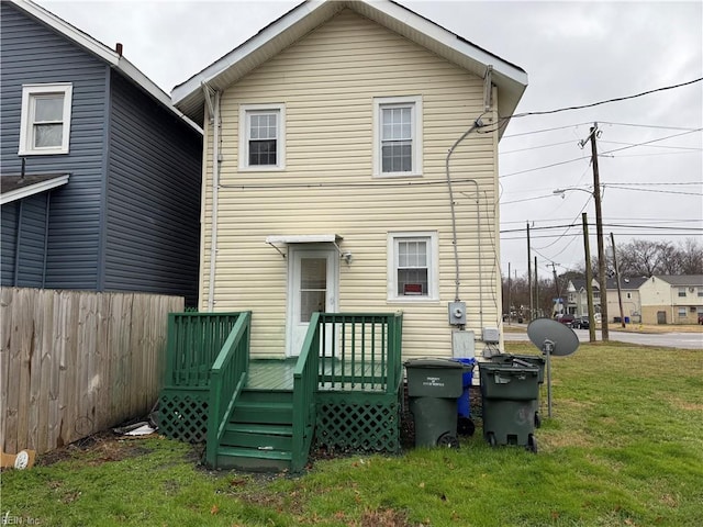 rear view of property featuring a wooden deck and a yard