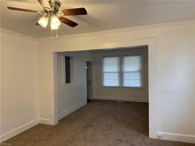 unfurnished room featuring crown molding, ceiling fan, and dark colored carpet