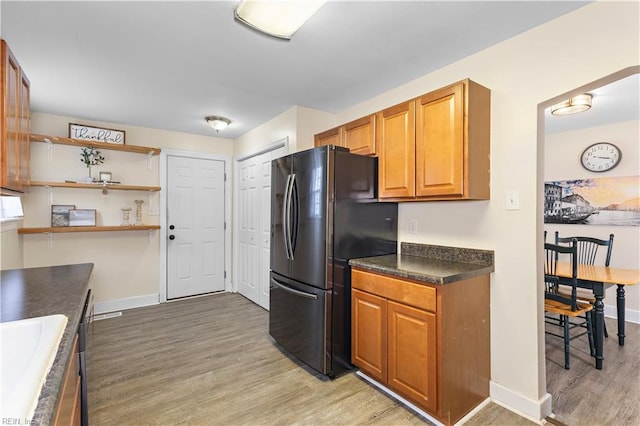 kitchen with fridge, sink, and light hardwood / wood-style floors