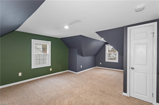 additional living space with vaulted ceiling and light carpet