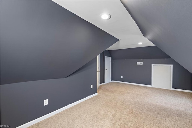 bonus room with light carpet and vaulted ceiling