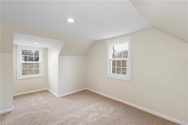 additional living space with vaulted ceiling and light carpet