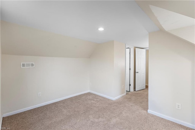 additional living space with lofted ceiling and light carpet