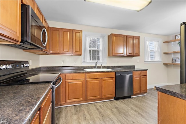 kitchen featuring appliances with stainless steel finishes, sink, and light hardwood / wood-style floors