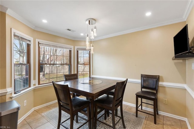 dining room featuring crown molding and light tile patterned floors