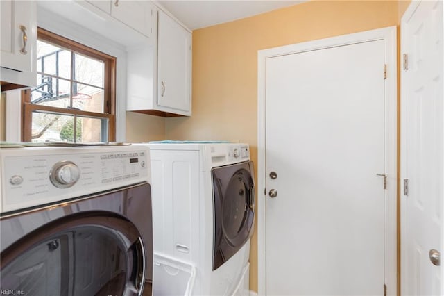 clothes washing area featuring cabinets and washing machine and clothes dryer