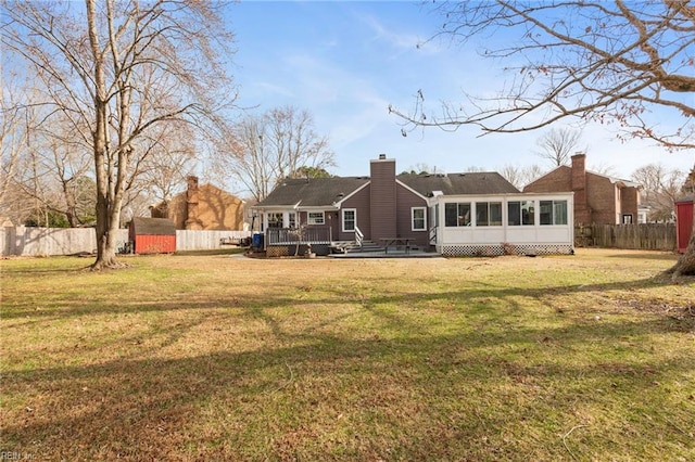 rear view of property featuring a sunroom and a yard