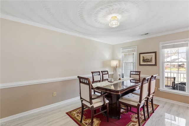 dining room featuring light hardwood / wood-style flooring and ornamental molding