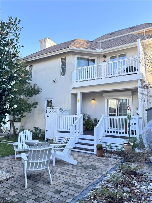 rear view of property with a patio and a balcony