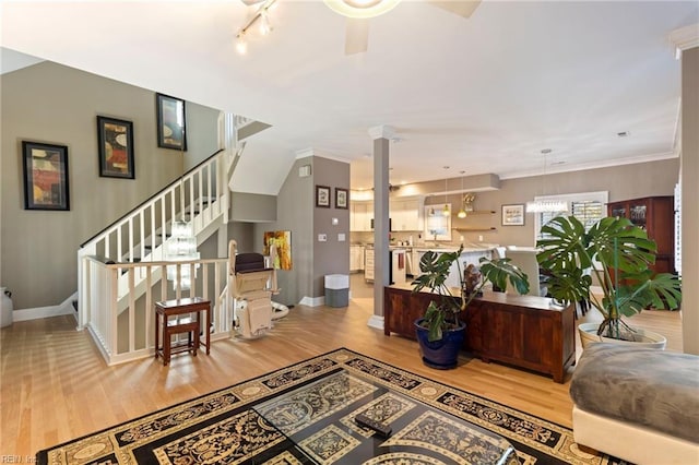 interior space with decorative columns, crown molding, and light hardwood / wood-style flooring