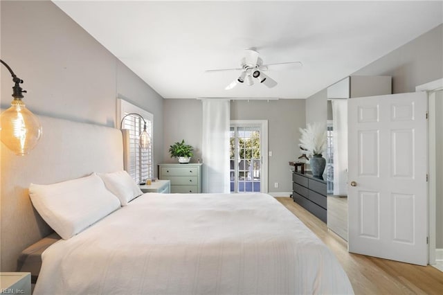 bedroom with multiple windows, access to exterior, ceiling fan, and light hardwood / wood-style flooring