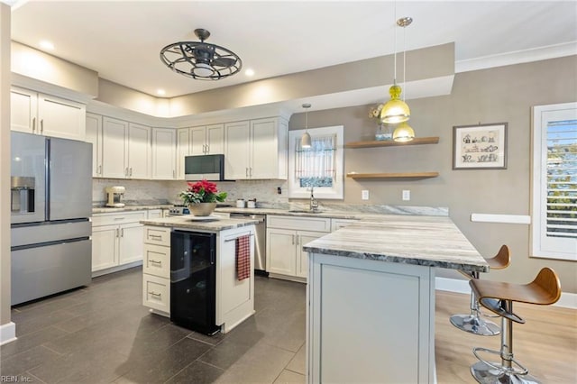 kitchen featuring appliances with stainless steel finishes, sink, a kitchen island, and white cabinets