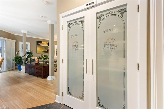 bathroom with crown molding, decorative columns, hardwood / wood-style floors, and french doors