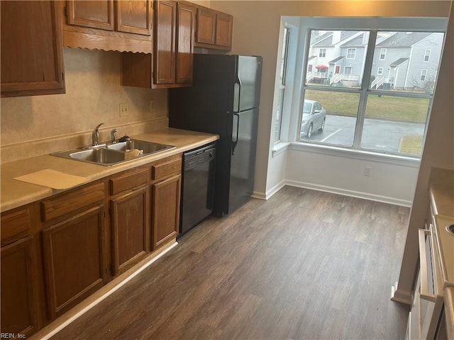 kitchen with dark hardwood / wood-style flooring, sink, and black appliances