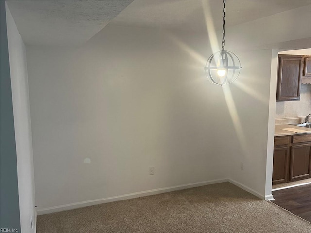 unfurnished dining area featuring sink and dark colored carpet