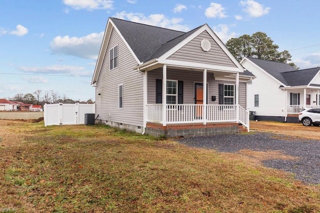 view of front facade with a front yard, cooling unit, and covered porch