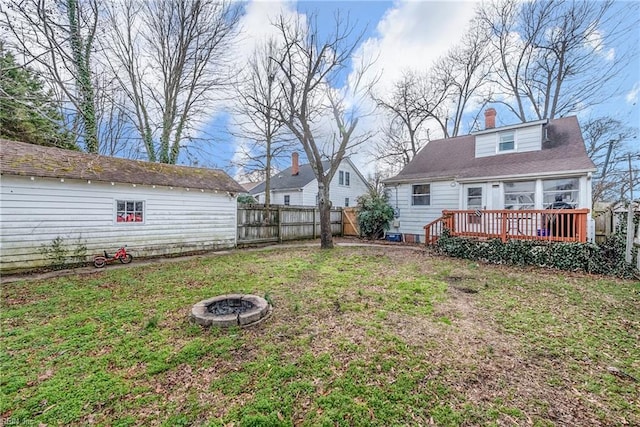 view of yard featuring an outbuilding, a deck, and an outdoor fire pit