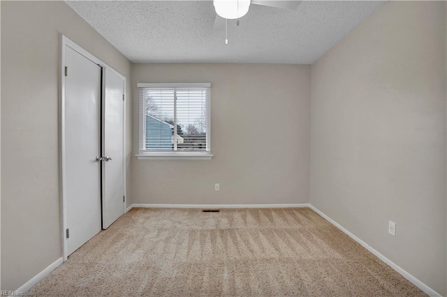 unfurnished room featuring light carpet and a textured ceiling