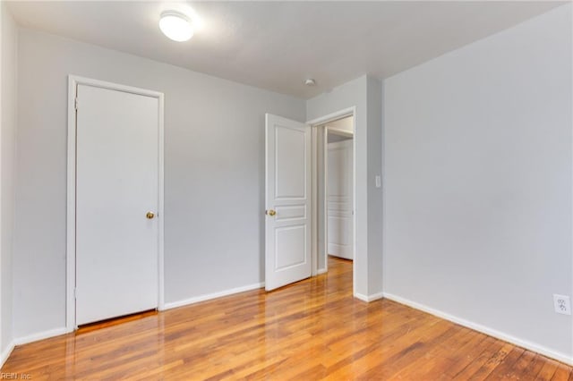 unfurnished bedroom with light hardwood / wood-style floors and a closet