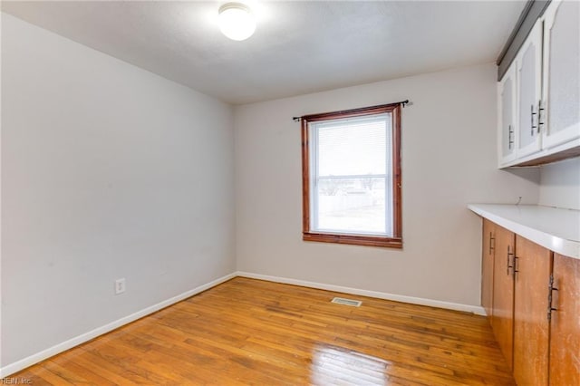 unfurnished dining area featuring light wood-type flooring